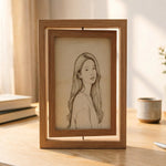 Square rotating wooden picture frame with light oak finish displaying a pencil sketch portrait