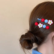 Daisy flower hair clips worn on a low bun ponytail hairstyle