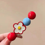 White daisy flower clip with cherry red and sky blue beads detail view
