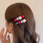 Daisy flower beaded hair clips worn on the side of brown wavy hair