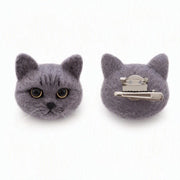 Two gray felt cat head hair clips shown on a white background, with one clip facing forward to show the face details and the other showing the silver metal claw fastener back.
