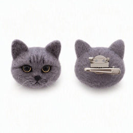 Two gray felt cat head hair clips shown on a white background, with one clip facing forward to show the face details and the other showing the silver metal claw fastener back.