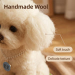 A close-up of a small white dog wearing a chain collar with a round tag, with overlaid text reading 'Handmade Wool,' 'Soft touch,' and 'Delicate texture.' The image appears to be marketing the dog collar rather than showing a clean standalone product shot, and a real animal is present, so subject_type is Lifestyle.
